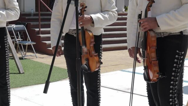 group of mariachi mexican music playing violin and singing in a public mexican fiesta at a park
