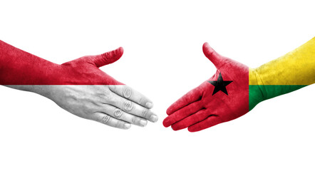 Handshake between Guinea Bissau and Monaco flags painted on hands, isolated transparent image.