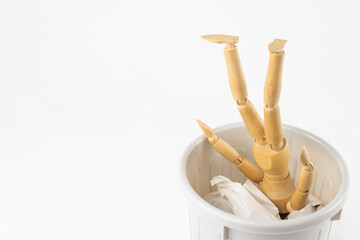 ごみ箱に入ったデッサン人形。人材の使い捨てイメージ