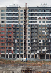 Construction of a residential building. View of the facade of an unfinished building.