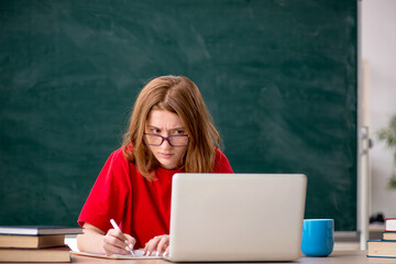 Young female student preparing for exams in the classroom