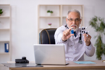 Old male doctor working in the clinic