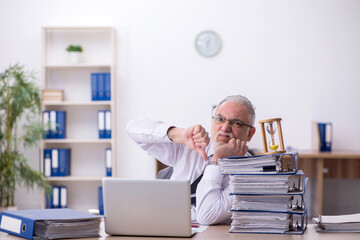 Fototapeta premium Old male employee in time management concept
