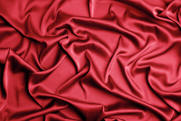 Delicate red silk fabric as background, top view