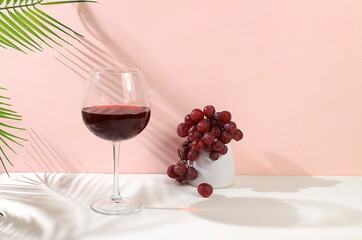 Modern still life with red wine, margarita alcoholic cocktail and grapes on a pastel background with long hard shadows, minimal concept for a bar, cafe, advertising banner, selective focus,