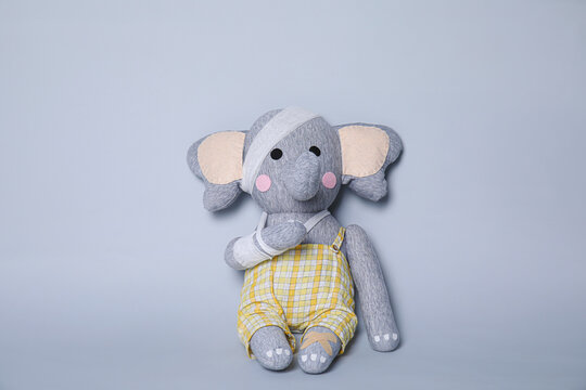 Toy Elephant With Bandages On Light Grey Background