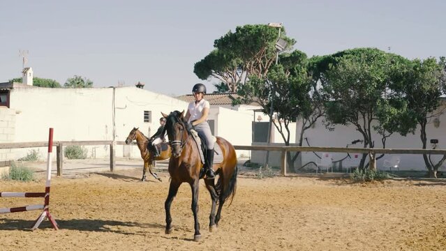 4K video of a young rider trotting his horse diagonally in the arena in a dressage exhibition.