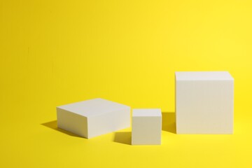 Fototapeta premium Scene for product presentation. Podiums of different geometric shapes on yellow background
