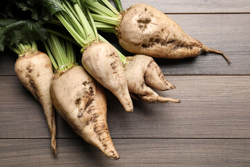 Fresh sugar beets with leaves on wooden table, flat lay