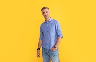 smiling mature man with wrist watch on yellow background, fashion