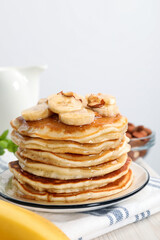 Tasty pancakes with sliced banana served on white wooden table, closeup. Space for text