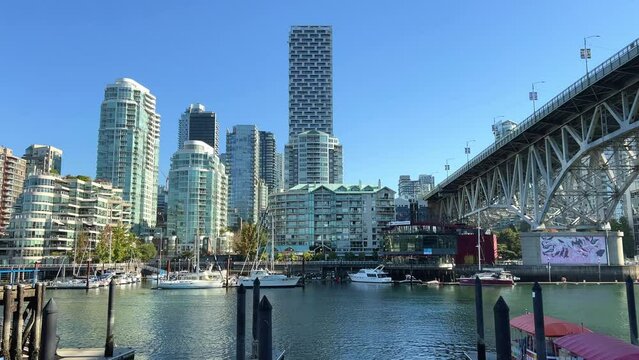  Dolly shot of Yachts moored at Granville Island, Vancouver, British Columbia, Canada. The Vancouver skyline including the Burrard Street Bridge is seen in the background. High quality 4k footage
