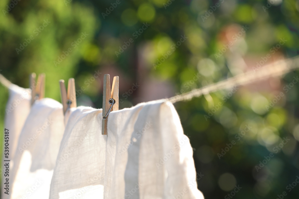 Canvas Prints Washing line with drying shirt against blurred background, focus on clothespin