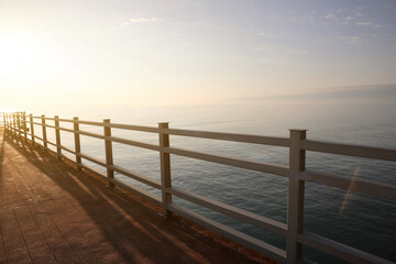 Fototapeta na wymiar Picturesque view of pier near sea at sunrise