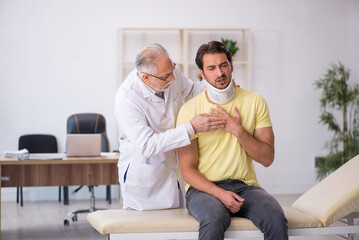 Young male neck injured patient visiting old male doctor