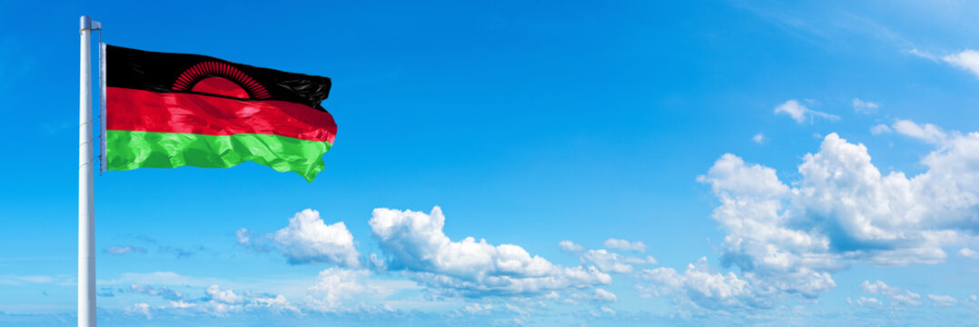 Malawi flag waving on a blue sky in beautiful clouds - Horizontal banner
