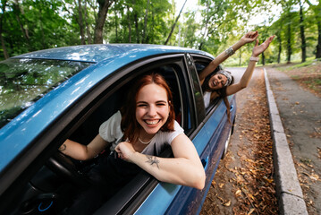 Two girlfriends fool around and laughing together in a car