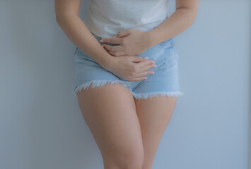 The girl holds her stomach with her hands. Diseases of the genitourinary system. Women Health. Soft focus