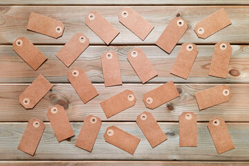 Lots of blank address tags scattered randomly. Flatlay. Several gift tags on wooden background. The concept of targeted delivery of gifts. Top view.