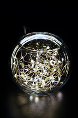 Mason glass jar with glowing garland inside, close up of an atmospheric but simple room festive decoration