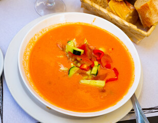 Image of spanish traditional cold soup gazpacho in bowl with tomatoes and cucumber..
