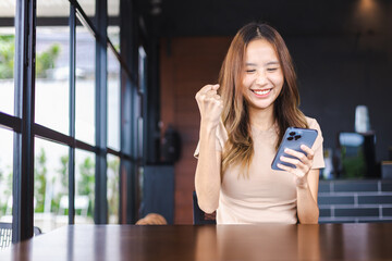 Successful Asian woman entrepreneurs using mobile smartphone in cafe for their businesses, People working with technology and modern devices concept