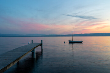 Fototapeta na wymiar Barque et son ponton, au lever du soleil sur le lac