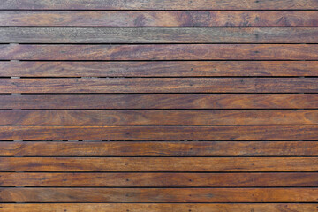 panoramic texture of a mistreated varnished wood wooden fence surface with metal rivets pattern