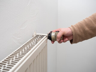 Saving energy by adjusting temperature on thermostat on radiator. No face.
