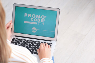 Woman with laptop activating promo code while doing online shopping, closeup. Space for text