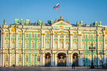 View of Winter palace, Russian flag and St. Petersburg at golden sunset, Russia