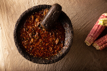 Molcajete with chile de arbol sauce. Traditional mexican version of mortar and pestle handmade of...