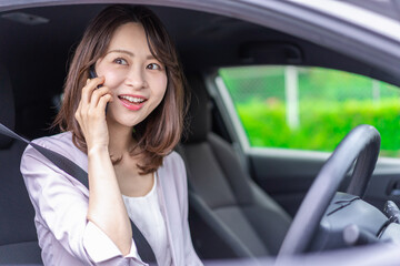 スマホを使いながら車を運転する女性