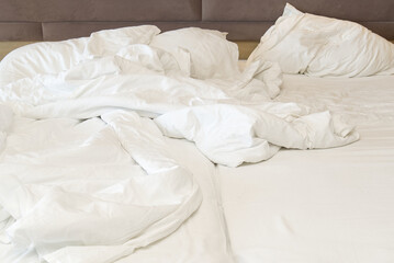 wrinkled bed after a stormy night of love. Closeup on soft white and crumpled blanket in bedroom for Valentine backdrop.