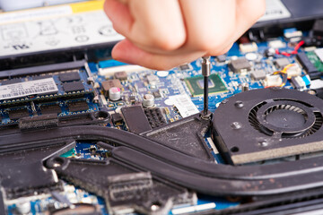 Hands fixing motherboard of pc or laptop notebook close up in service. Laptop repair service. PC...