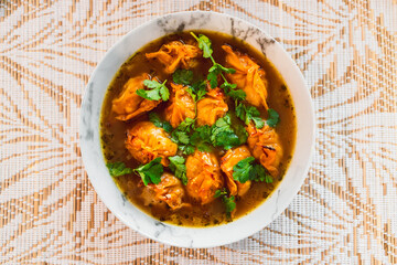 healthy plant-based food, vegetable wonton dumplings in spicy broth topped with coriander