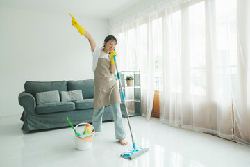 Young woman having fun while cleaning at home.