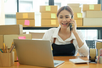 Female online business owner talking on phone with clients.