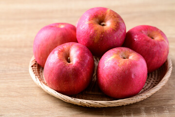Naklejka na ściany i meble Red apple fruit in basket on wooden background, Healthy fruit