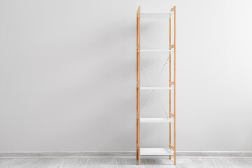 Empty wooden shelving unit near light wall in room