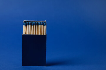 Box with new matches on blue background