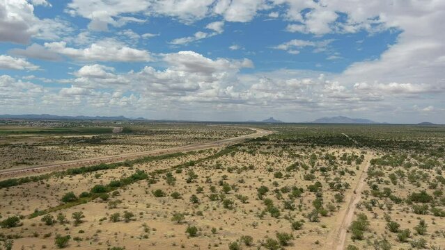 Wide aerial shot of the Sonoran desert in Arizona, slow moving drone shot with dirt roads