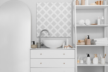 Fototapeta na wymiar Modern sink, big mirror and shelf unit with different bath accessories near white wall