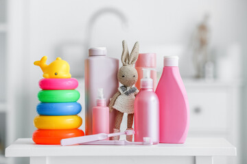 Bath accessories for children and different toys on table in bathroom