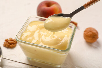 Glass bowl of delicious vanilla pudding on light background, closeup
