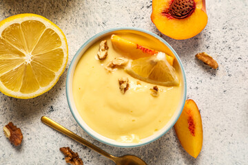 Bowl of delicious vanilla pudding with fruits on light background, closeup