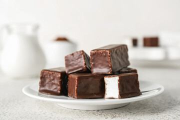 Plate with tasty bird's milk candies on light background, closeup