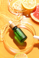 Bowl with bottle of vitamin C serum in water on color background