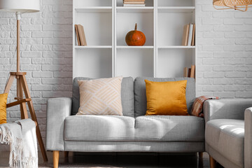 Interior of modern living room with grey sofa and shelving unit