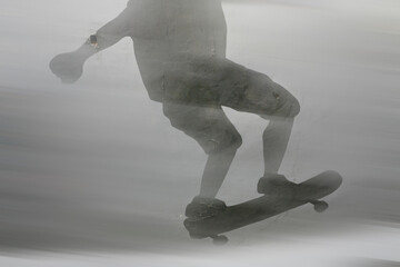 Motion blur black silhouette of a skater who is depicted with paints on the wall